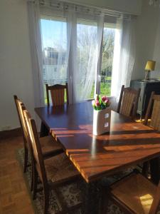 een eettafel met stoelen en een groot raam bij La Haute Maison - Merrien - GR34 in Moëlan-sur-Mer