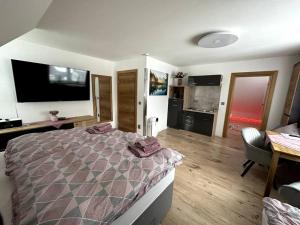 a bedroom with a bed and a desk and a kitchen at Haus an der Sieber Zimmer 3 in Herzberg am Harz