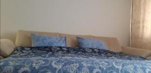 a bed with blue and white sheets and blue pillows at Apartman A1 in Bijeljina