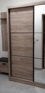 um armário com uma porta de madeira num quarto em Apartman A1 em Bijeljina