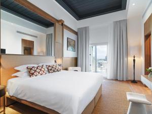 a bedroom with a large bed and a large window at Leonardo Boutique Hotel Larnaca in Larnaka