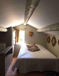 een slaapkamer met een groot bed en een raam bij BASTIDON FARFALLINA in Puyvert