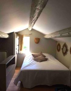 a bedroom with a large bed with a window at BASTIDON FARFALLINA in Puyvert