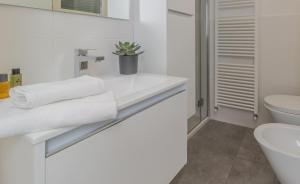 a white bathroom with a sink and a toilet at La terrazza di Marta in Varenna +44 photos