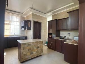 a kitchen with brown cabinets and a island in it at Dar Villa in Dar es Salaam