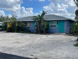 a blue house with a palm tree in front of it at Waterfront Condo #7 in Punta Gorda