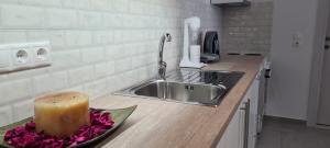 um balcão de cozinha com um lavatório e uma vela num prato em Brand new cozy apartment em Mesaíon Karlovásion