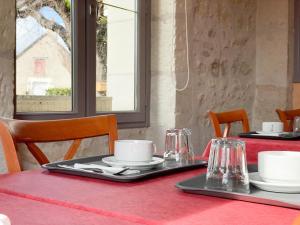 una mesa con un mantel rojo y platos y gafas en Relais Touraine Sologne, en Noyers-sur-Cher 60 fotos más