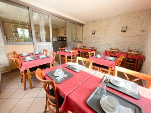 a restaurant with tables and chairs with red tablecloths at Relais Touraine Sologne in Noyers-sur-Cher