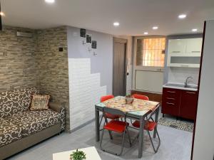 eine Küche und ein Wohnzimmer mit einem Tisch und einem Sofa in der Unterkunft Casa Raccuglia in Palermo