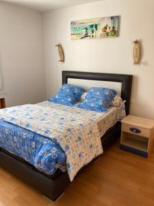 um quarto com uma cama com edredão azul em Chez Bernard pavillon proche Disneyland et Paris em Coulommiers