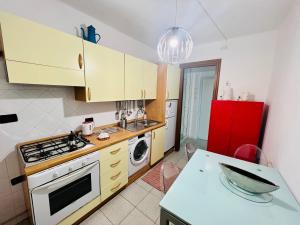 a kitchen with a stove and a red refrigerator at CASA BARBARA in Ventimiglia +16 photos