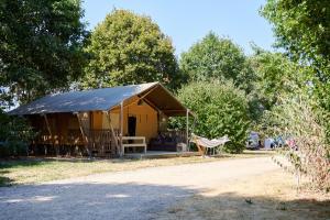 Zelt mit Hängematte vor einigen Bäumen in der Unterkunft Glamping Vendée in Saint-Julien-des-Landes