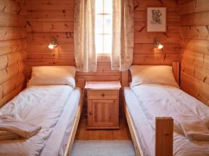 2 camas en una cabaña de madera con ventana en Bergebu, en Stranda