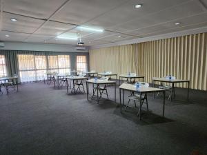 a classroom with tables and chairs in a room at Postmasburg Inn in Postmasburg
