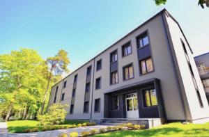 un edificio blanco con ventanas negras y césped en Jurmala Dzintari, en Jūrmala 4 fotos más