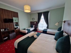 a hotel room with two beds and a window at Lyndon Guesthouse in Dublin +22 photos