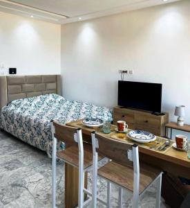 a bedroom with a bed and a table and chairs at Studio avec vue directe mer in Monastir
