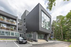 un edificio negro con un coche aparcado en un estacionamiento en Jurmala Dzintari, en Jūrmala