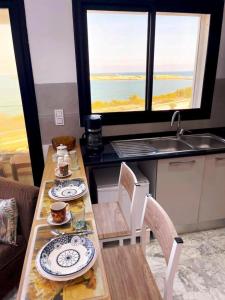 a kitchen with a table with plates of food on it at Studio avec vue directe mer in Monastir