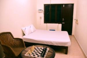 een kamer met een bed en een schaakbord op een tafel bij Steve homestay, near white town, near rock beach in Pondicherry
