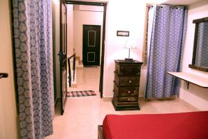 un pasillo con cortinas moradas y un tocador en una habitación en Steve homestay, near white town, near rock beach, en Pondicherry