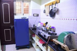 een keuken met een blauwe koelkast en een fornuis bij Steve homestay, near white town, near rock beach in Pondicherry