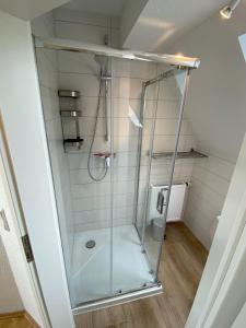 a shower with a glass door in a bathroom at Ferienhaus am Seedeich in Emden