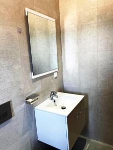 La salle de bains est pourvue d'un lavabo blanc et d'un miroir. dans l'établissement Studio avec vue directe mer, à Monastir