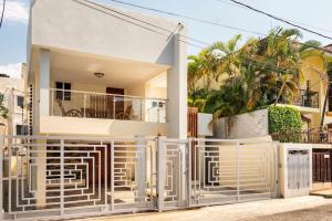 a white fence in front of a house at Villa Bayardo in San Felipe de Puerto Plata