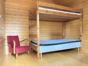 een slaapkamer met een stapelbed en een rode stoel bij Cozy Lakefront Cabin 