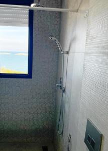 a shower stall in a bathroom with a window at Studio avec vue directe mer in Monastir