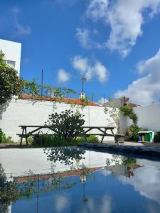a pool with a picnic table and clouds in the sky at City's Hostel Ponta Delgada in Ponta Delgada