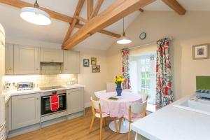 a kitchen and dining room with a table and chairs at 2 Sulphur Wells at Broughton Sanctuary in Broughton