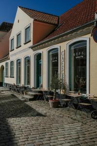 a building with tables and chairs in front of it at KEFS Guesthouse & Café in Ærøskøbing