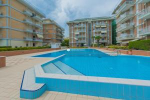 una piscina frente a algunos edificios de apartamentos en Residence Puerto Del Sol Immobiliare Pacella, en Lido di Jesolo