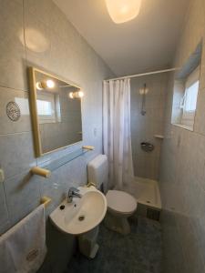 a bathroom with a sink and a toilet and a mirror at Apartments Cacija in Trogir