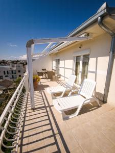 two white chairs on a patio with a table at Apartments Cacija in Trogir