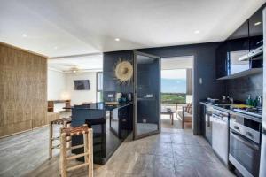 a kitchen with blue walls and a counter and chairs at Kube Taghazout - Luxe - 5Px in Taghazout