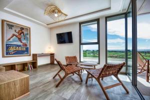 a living room with two chairs and a table and windows at Kube Taghazout - Luxe - 5Px in Taghazout