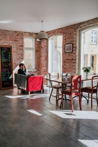 a woman sitting in a chair in a room with a table at KEFS Guesthouse & Café in Ærøskøbing