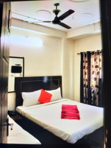 1 dormitorio con 1 cama con 2 almohadas rojas en Hotel Shiva Haridwar - nearby bus and railway station, en Haridwar