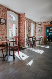 a room with tables and chairs and a brick wall at KEFS Guesthouse & Café in Ærøskøbing +42 photos