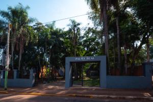 una puerta en la entrada de un parque con árboles en Palma Real Bungalow en Puerto Iguazú