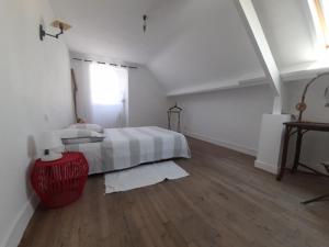 a white bedroom with a bed and a wooden floor at abri du marin in Séné