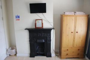 a room with a fireplace and a tv on a wall at The Plough Inn in Swindon