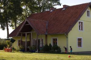 two children playing in front of a house at Komfortowy dom wakacyjny dla kilku rodzin 