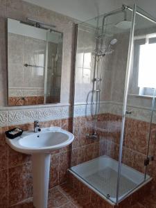 a bathroom with a sink and a shower at Casa das Palmas in Óbidos