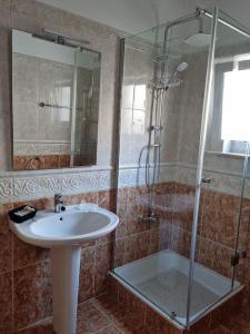 y baño con lavabo y ducha. en Casa das Palmas, en Óbidos