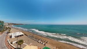 widok na plażę z parasolami i oceanem w obiekcie Olimpo II The Cruise - Front Line Beach w mieście Fuengirola